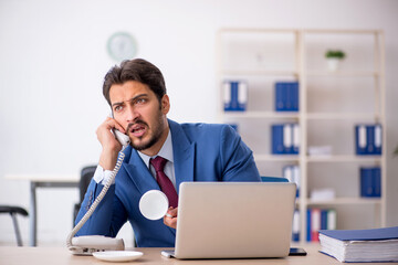 Young male employee drinking coffee during break