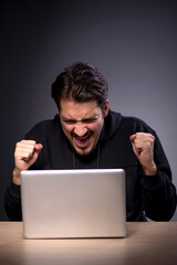 Young male hacker on grey background