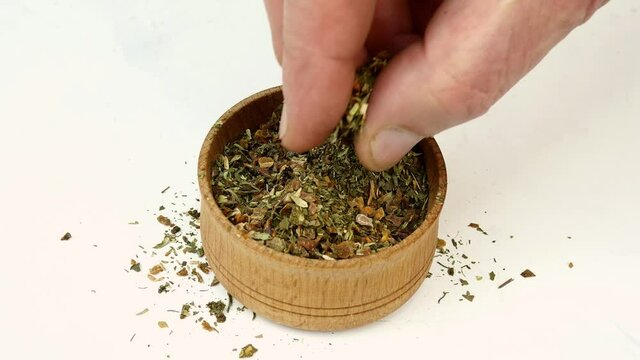 Chef taking spices Italian herbs, basil, oregano.