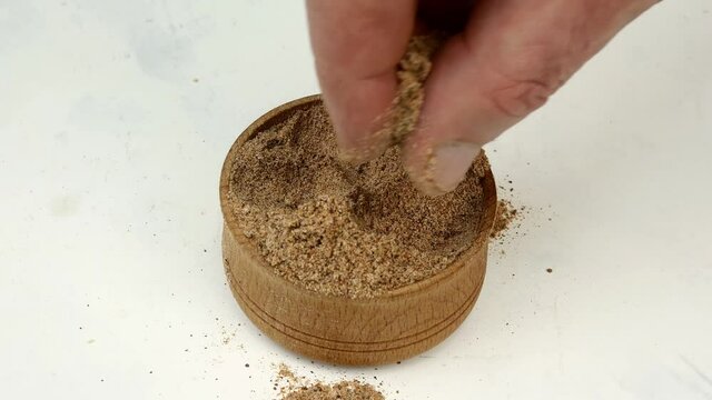 Chef taking chopped dry nutmeg powder spices.