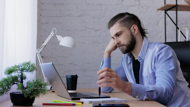 Depressed man overworked on laptop computer. Stressed worker recieved bad online news, failed exam results, had lack of creative ideas. Burnout syndrome, overworking, depression, apathy.