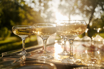 Table set for an event party or wedding reception. Banquet table design. Festive glasses with champagne and white wine.
