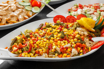 A mix of corn, pepper, tomatoes and herbs is on a large plate.