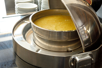 Freshly cooked hot mashed soup in a large saucepan. The concept of public catering