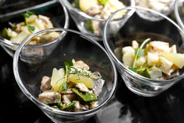 A light snack of potatoes, mushrooms, chicken meat and herbs in transparent serving cups.