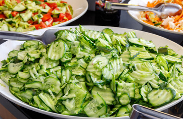 Fresh cucumbers, cut into slices, are in a large plate