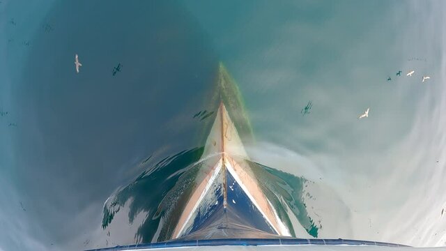 View from above. The bow of the ship is cut by the waves of the calm northern sea.