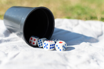 Black goblet with white dice with scattered blue or red values