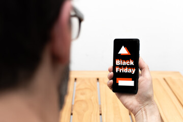 Hand holding a smartphone that on the screen announces black friday