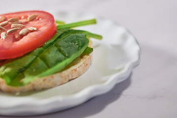 Healthy meal of rice cakes made with organic ingredients, spinach and tomato..