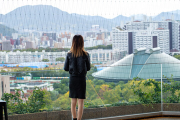 展望室から広島市街の風景を眺める女性の後ろ姿