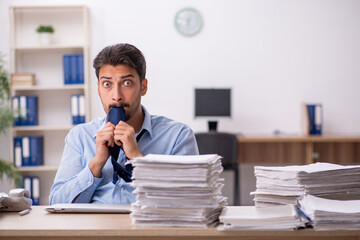 Young male employee and too much work in the office