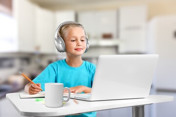 Smiling little child in headphones have a video call distant class using a laptop. Education concept. Back at school after covid-19 quarantine.