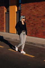 Woman walking the streets of the city. Glasses, jacket, jeans, clothing suitable for a business woman. Modern woman lifestyle. Pretty young woman. Urban