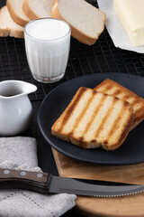 Toasted bread with a cup of milk and coffee, selective focus.