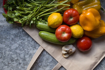 Verduras saludables, frescas y coloridas en bolsa ecológica en la mesada de la cocina