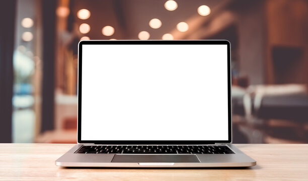 Laptop blank screen on wood table with blurred coffee shop cafe interior background and lighting bokeh, mockup, template for your text, Clipping paths included for background and device screen