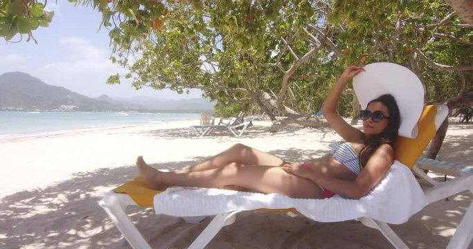 Latin Woman Rests on Sun Lounger on Beach in Cool Shade at Playa Teco Maimon, Dominican Republic