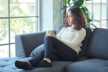 Lifestyle relaxes. Latin woman relaxing at home with a cup of hot tea or coffee.