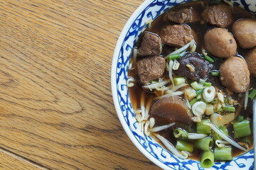 Top view rice noodle with pork meatballs on wood table.