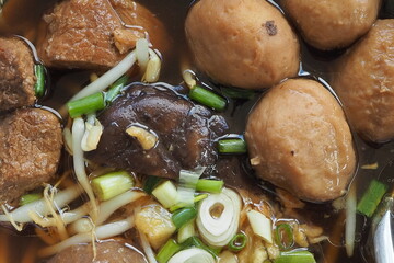Top view rice noodle with pork meatballs on wood table.