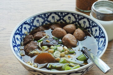 Top view rice noodle with pork meatballs on wood table.