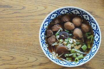 Top view rice noodle with pork meatballs on wood table.