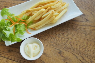 French fries or fried potatoes with 
mayonnaise on wood table, top view