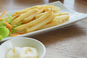 French fries or fried potatoes with 
mayonnaise on wood table, top view