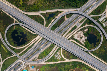 Aerial view of highway junctions with roundabout. Bridge roads shape circle in structure of...