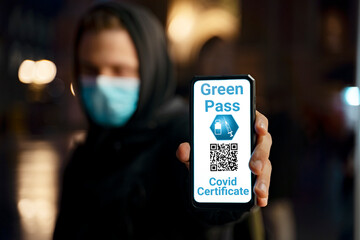 Covid19 certificate, GREEN PASS concept , closeup shot, unrecognizable young man holding his smartphone with qr code 