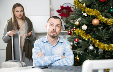 Woman leaving her irritated boyfriend and go away after argument on the eve of New Year