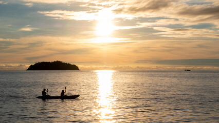Fototapeta na wymiar Kayakers at sunset in the sea at Koh Chang island in the Gulf of Thailand