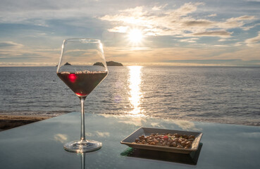 Red wine with tropical sunset in the background