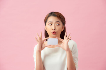 Young Asian beautiful woman holding blank card isolated on pink background
