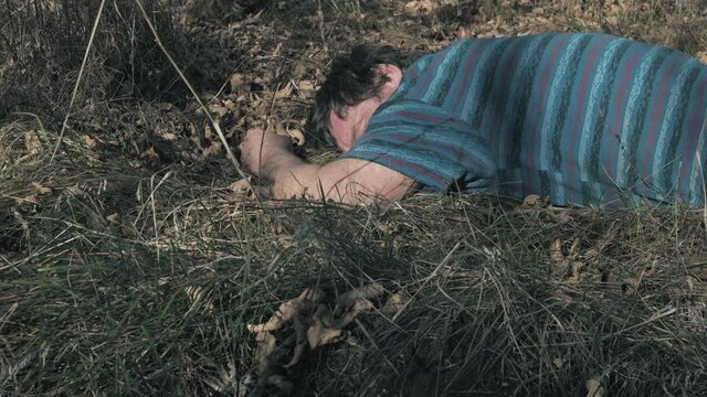 found the body of a dead murdered man in the woods who had an accident lying on the grass close-up.