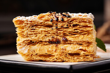 Slice of napoleon cake on the wooden background