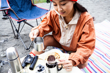 川辺でのソロキャンプ／コーヒーをドリップする女性
