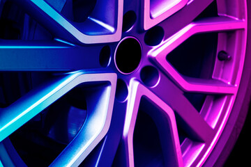 Car alloy wheel texture background in blue and pink tones. New alloy wheel for a car. Modern alloy...