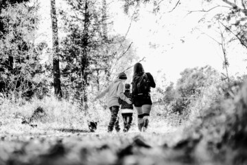 Family walking in the woods. Black and white toned photo
