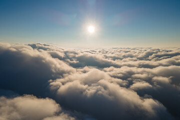 Aerial view from airplane window at high altitude of dense puffy cumulus clouds forming before...