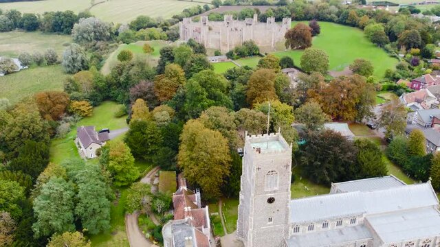 Aerial: St Michael's Church with Framlingham Castle at Suffolk, England - drone flying shot