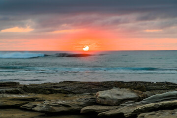 Obraz premium Sunrise seascape with rocky foreground