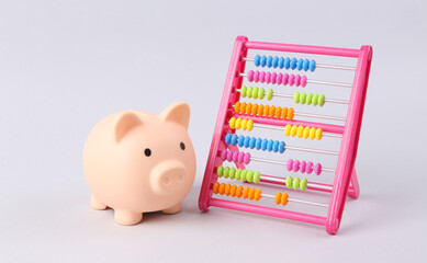 Colored abacus and piggy bank on white background. Counting, education, economy, business and...