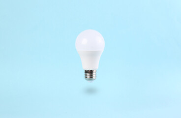 Floating light bulb on a blue background. Minimal idea concept