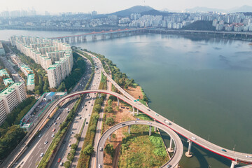 Hangang river bridge with cars and Seoul cityscape, aerial view.