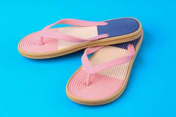 Colored flip flops on blue background