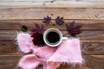 knitting wool scarf, hot coffee espresso with mable leaf in autumn season arrangement flat lay postcard style on background wooden