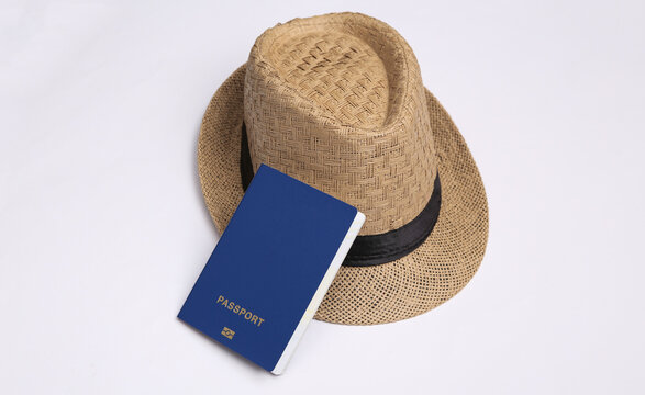 Straw hat with passport on white background. Travel concept