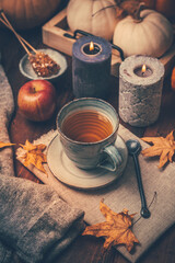 Hot tea with cookies, apple and fall foliage and pumpkins on wooden background